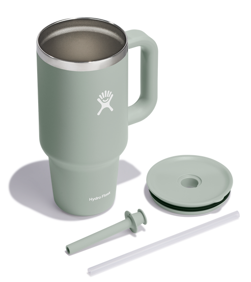 Green mug with a handle, lid, silicone coaster, and straw.