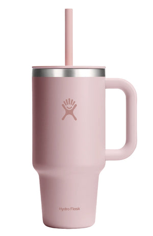 A light pink insulated cup with a handle, straw, and visible text "Hydro Flask".
