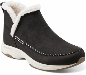 A black, ankle height, slip-on boot with white faux-fur lining and a thick, off-white sole.