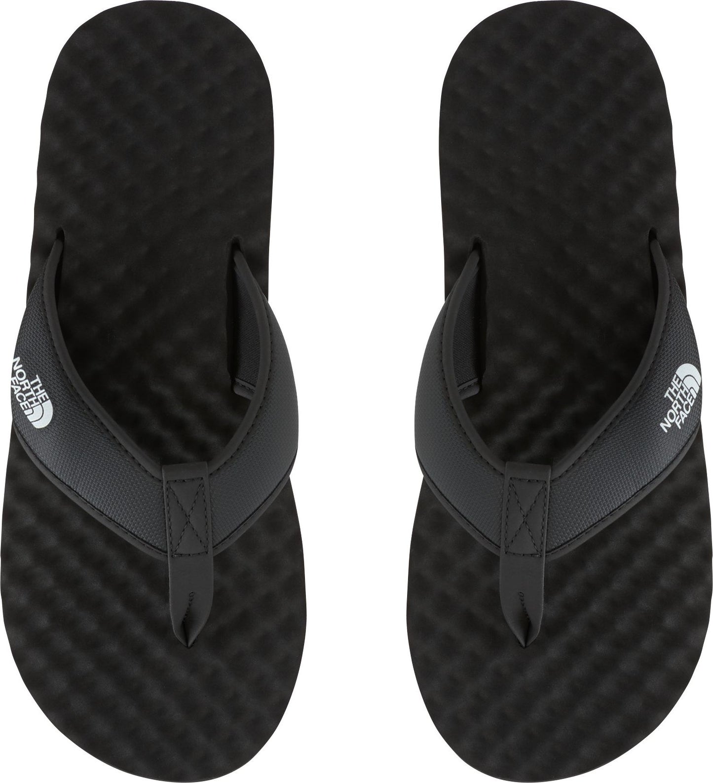 Overhead shot of a pair of black flip-flops with white logo on the strap.