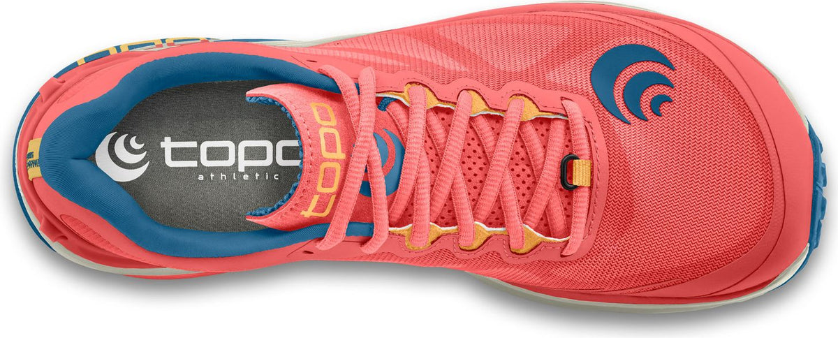 A running shoe with a coral colored upper and light coral laces, the inner sole is gray with a blue trim and has a Topo Athletic logo, there is a round blue logo near the toe of the shoe.