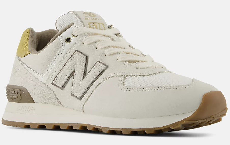 Off-white sneaker with a brown sole, grey 'N' logo on the side, and '574' on the tongue.