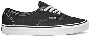 A black sneaker with white laces and a white sole, featuring a visible tag with the word "VANS" on the side.