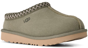 A slip-on shoe with an olive-green suede upper, featuring a decorative braided fabric trim around the collar and a visible UGG logo embossed on the side, set on a thick, light tan platform sole with a textured tread.