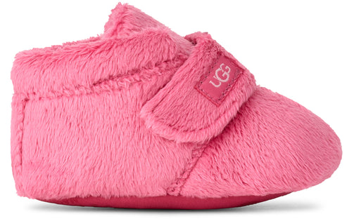 Pink fuzzy slipper with velcro strap that has the logo on the strap.
