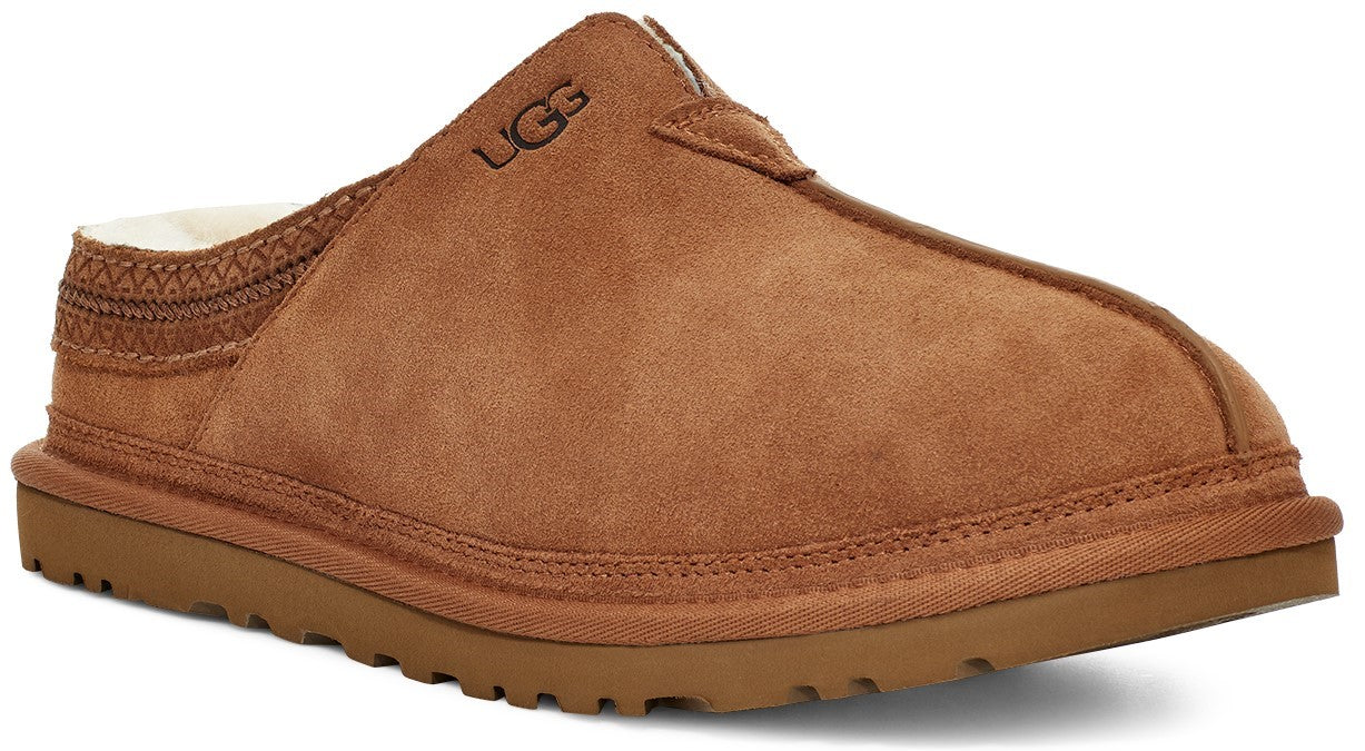 A brown suede slip-on slipper with a white shearling interior lining and a thick matching brown sole, featuring a stitched woven band detail at the heel and the embossed UGG logo on the upper side.