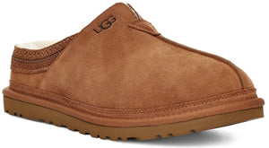 A brown suede slip-on slipper with a white shearling interior lining and a thick matching brown sole, featuring a stitched woven band detail at the heel and the embossed UGG logo on the upper side.
