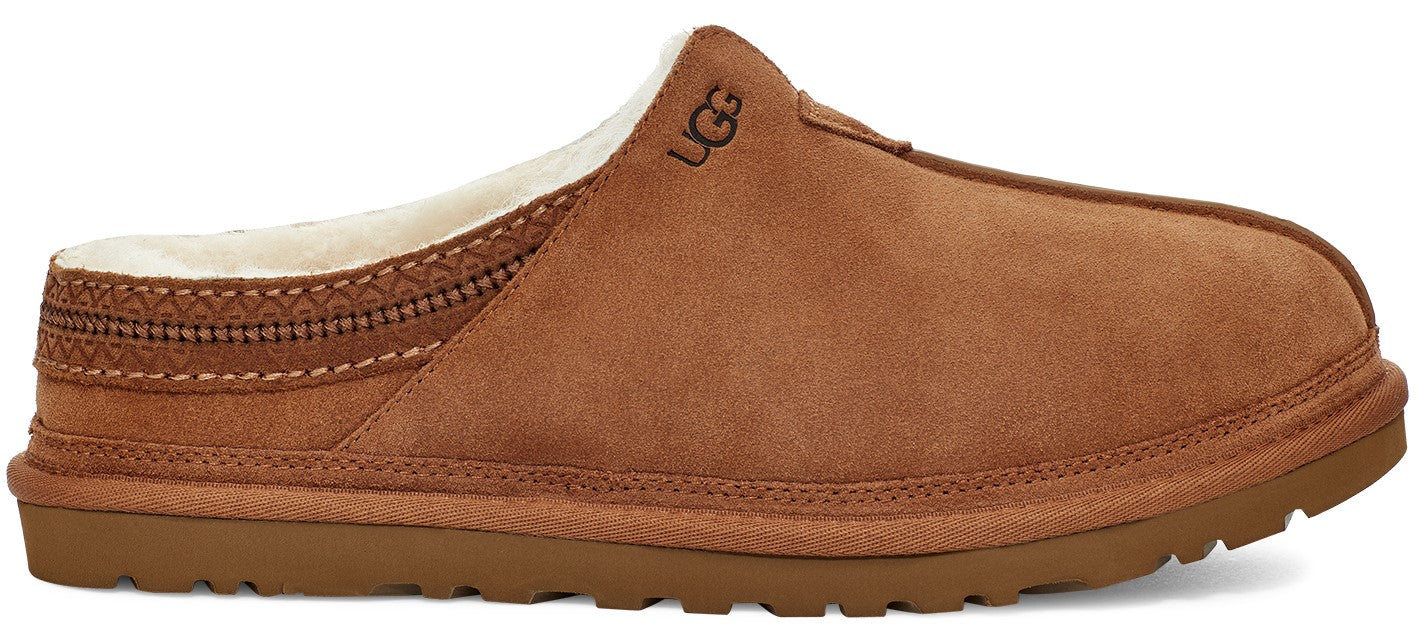 A side view of a brown suede slip-on slipper featuring a cream-colored plush lining, a decorative braided trim along the heel collar, and the logo UGG embossed on the upper side, set on a textured rubber sole.