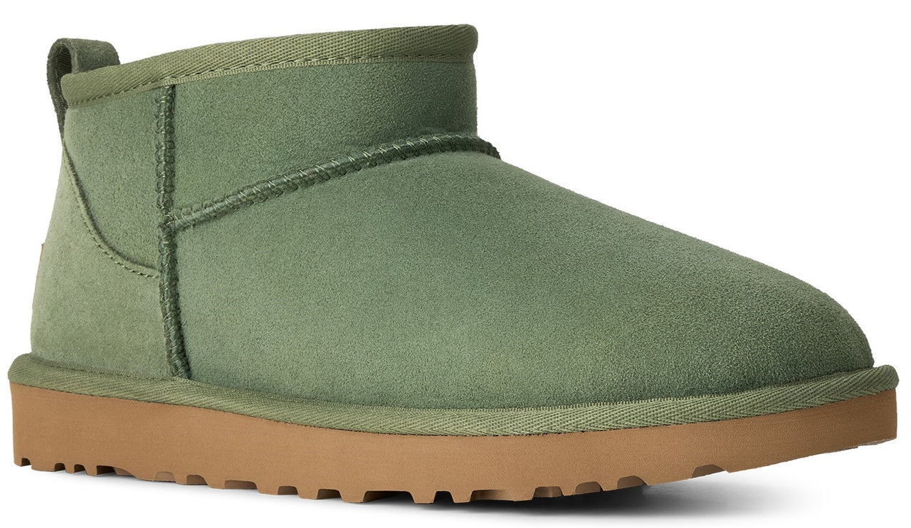 A sage green suede ankle boot with a tan rubber sole.