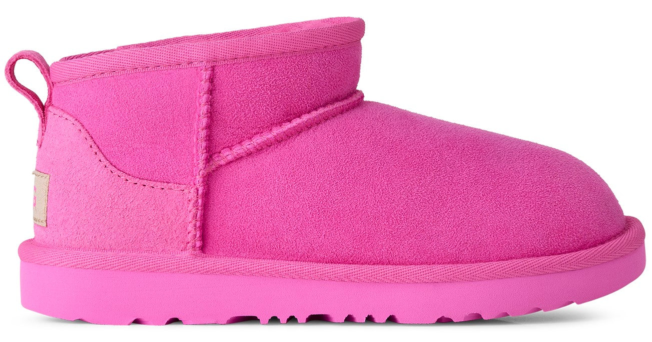A bright pink suede ankle boot with a low cut, a pull loop at the heel, and a flat rubber sole.
