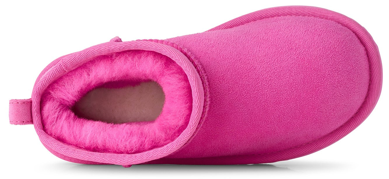 A top-down view of a bright pink suede ankle boot with a plush, matching pink faux fur lining.