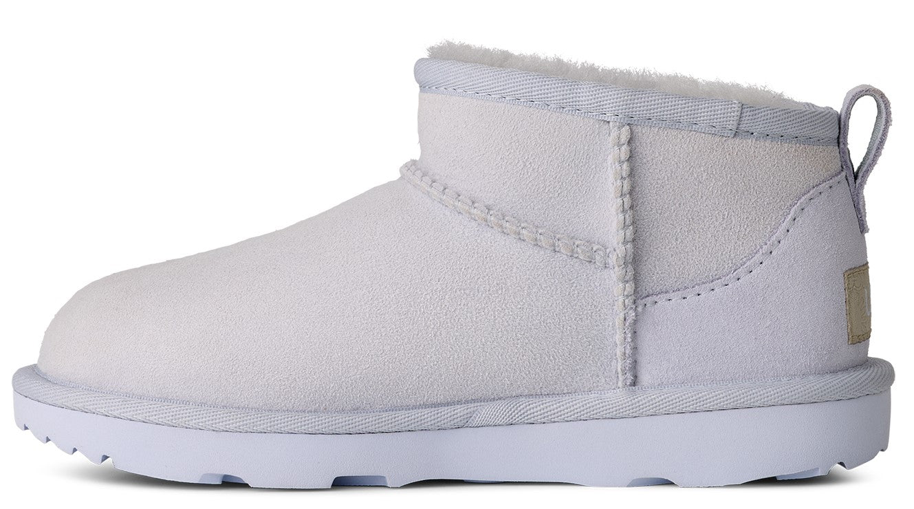 Ankle-high, white sheepskin boot with white soles and heel loop.