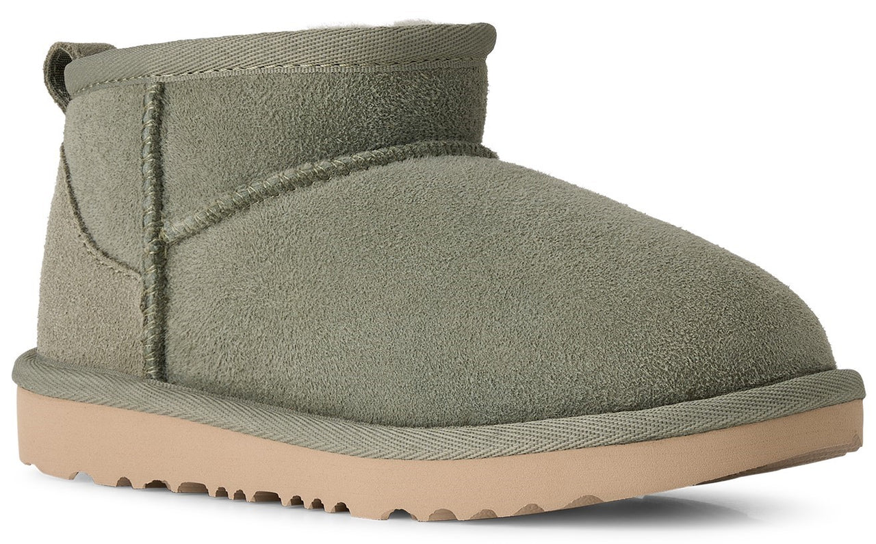 A sage green suede ankle-height winter boot with a thick light tan rubber sole and a heel pull tab.