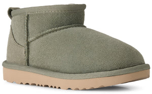 A sage green suede ankle-height winter boot with a thick light tan rubber sole and a heel pull tab.