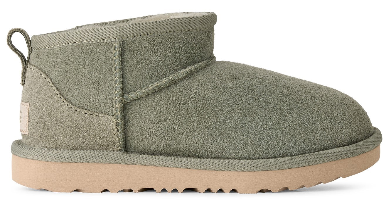 A sage green suede ankle boot with a pull loop at the heel and a thick, tan platform sole.