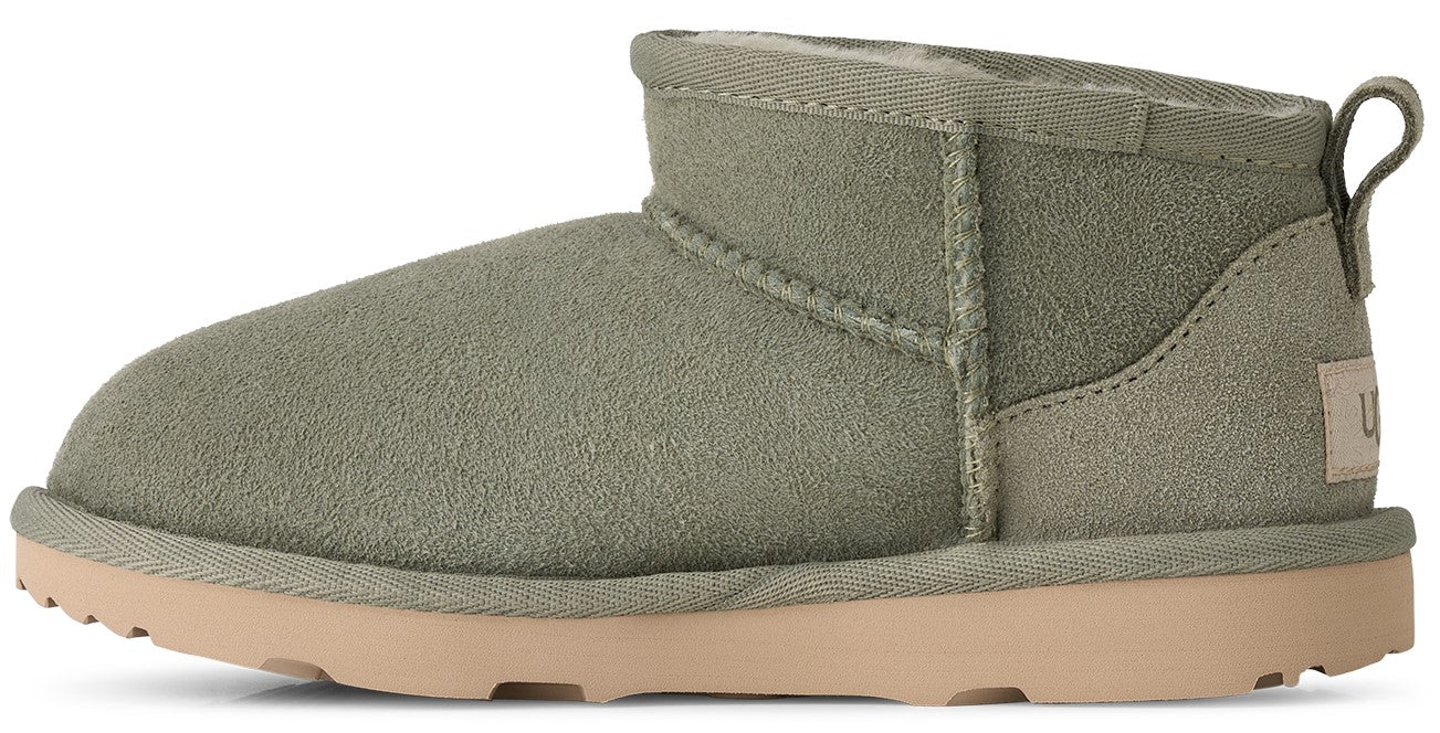 A low-cut suede ankle boot in olive green with a light tan rubber sole, showing a pull tab on the back and a visible brand tag on the heel.