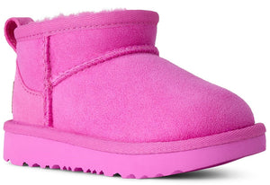 A bright pink, suede, ankle-high slip-on boot with a thick matching pink rubber sole and a plush interior lining.