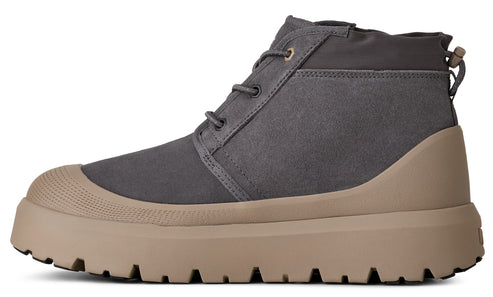 A gray chukka boot with a tan, lugged rubber sole.