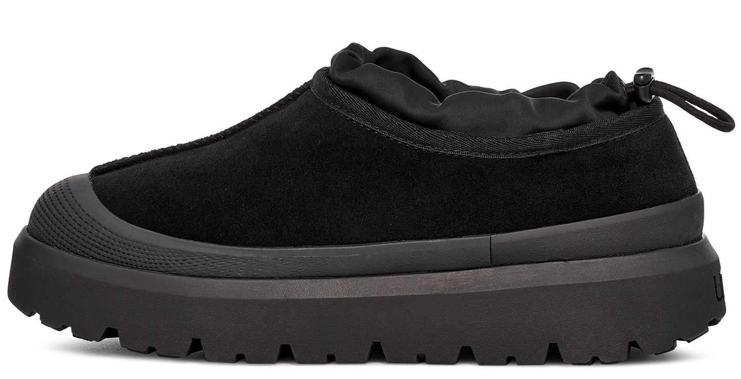 Black slip-on shoe with rounded toe and elastic collar on a thick textured sole.