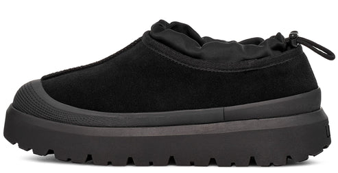 Black slip-on shoe with rounded toe and elastic collar on a thick textured sole.