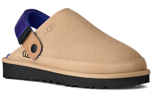 Sand color clog shoe with black sole and purple and black strap, and a logo on the side.