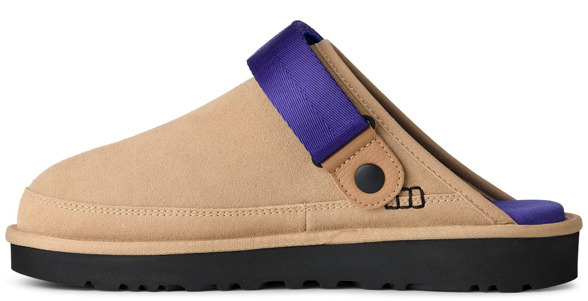 Beige slip-on shoe with a thick black sole and a purple strap.