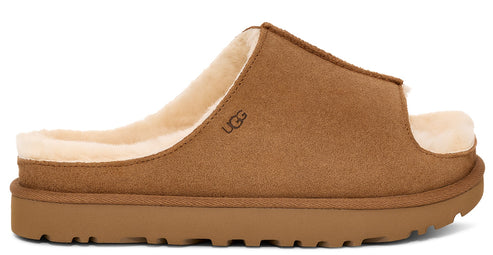 Side-view of a tan slide style slipper with shearling lining and logo.
