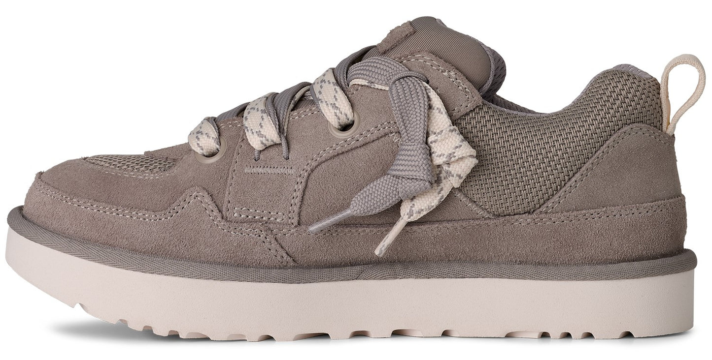Gray sneaker with thick white soles, suede and mesh details, and patterned laces.
