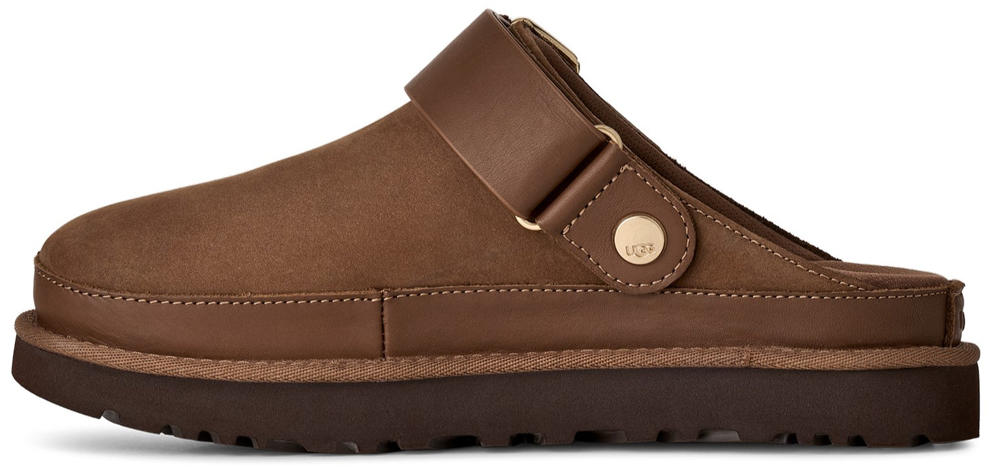 A brown leather slide-style slipper with a thick, dark brown platform sole, featuring an adjustable strap across the top with a gold-tone metallic stud button embossed with the logo UGG.