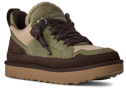 Low profile UGG sneaker with suede green and brown elements, tan canvas, dark brown textured laces, pull tab, and a thick, light brown sole.