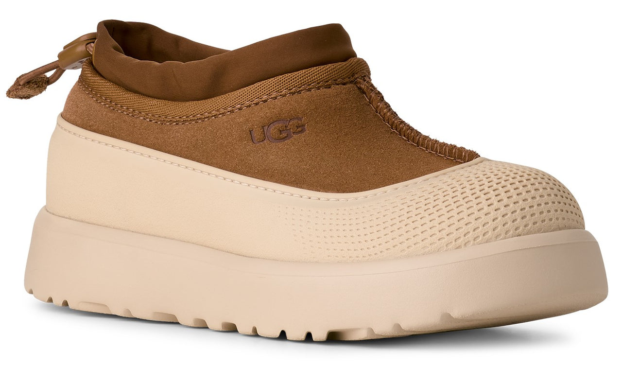 Tan UGG shoe with suede upper, cream rubberized lower and sole.