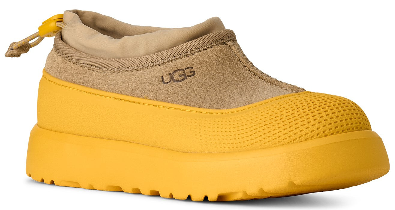 Short UGG boot with yellow waterproof base, tan suede and fabric upper, and tan drawstring.