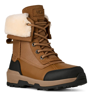 Leather lace-up boot in tan with black sole and cuff of white shearling; 'UGG' logo near the top.