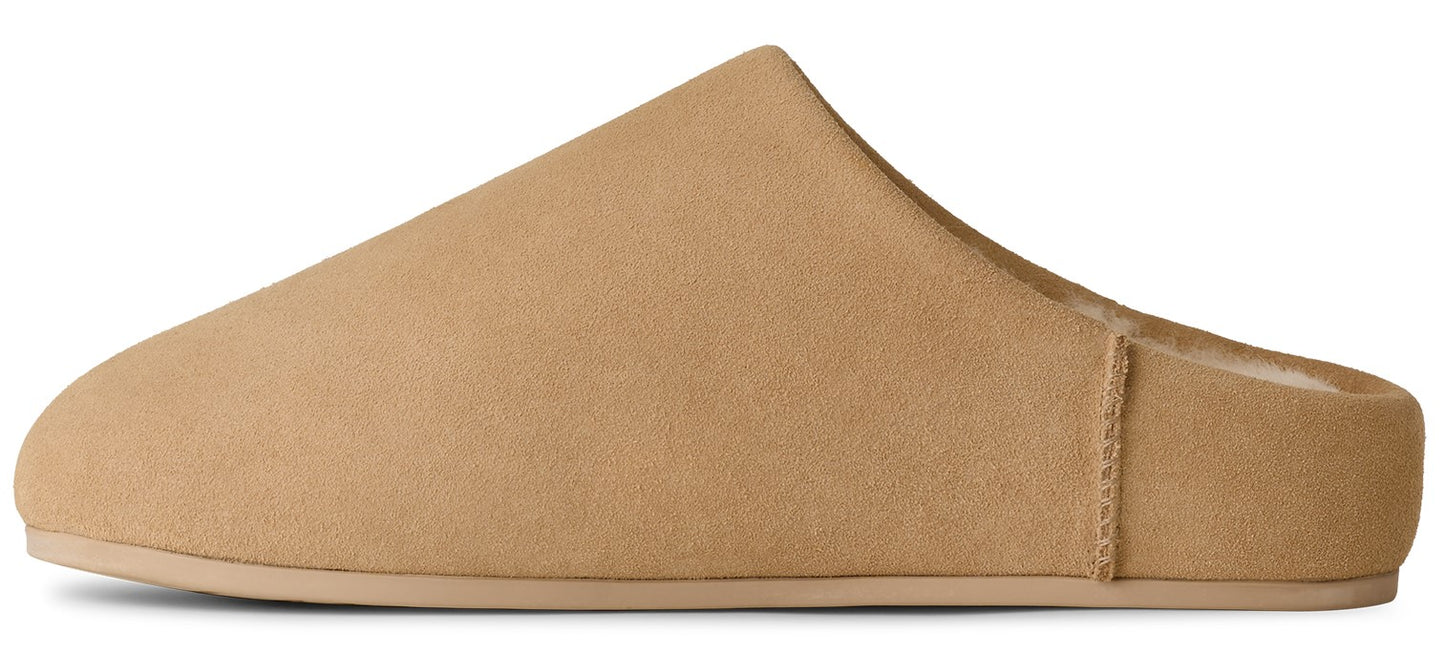 A tan, suede-like slipper with a closed toe and a slip-on style.