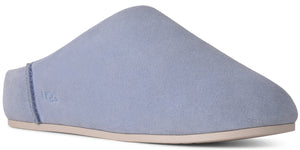 A light periwinkle suede slip-on shoe with a flat, beige sole and the word UGG embossed on the side heel.
