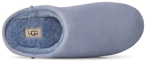 A light periwinkle blue suede slipper with a plush matching faux-fur interior lining and an UGG brand tag visible on the insole.