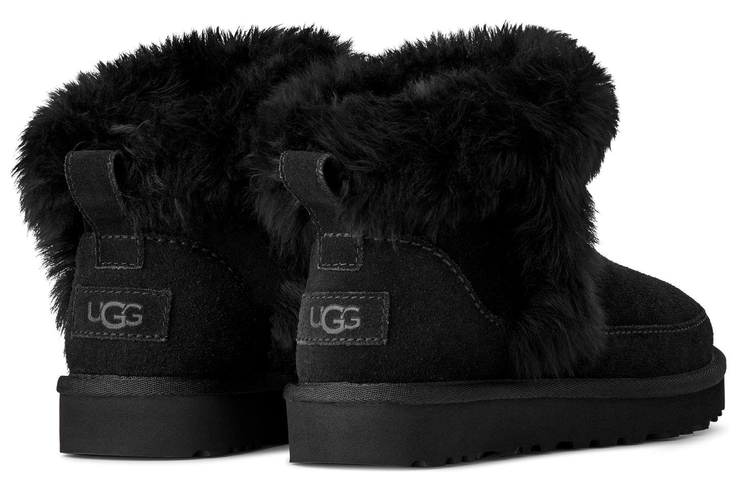 Pair of black, short boots with fuzzy trim and a fabric pull tab on the back.