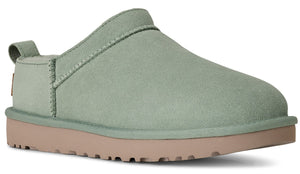 Suede slip-on shoe in light green with a tan sole and a small pull tab.