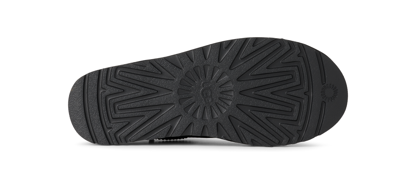 The sole of a shoe showing a star shaped tread pattern.
