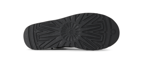 The sole of a shoe showing a star shaped tread pattern.