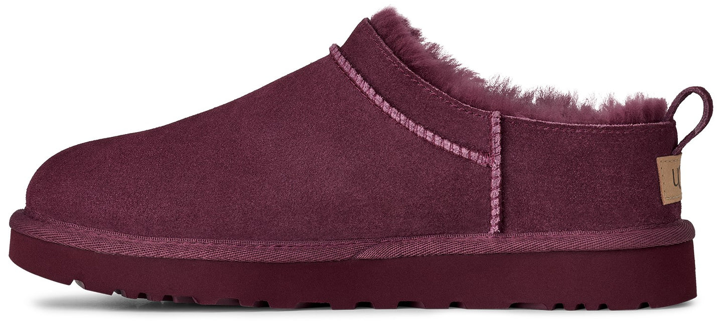 A burgundy UGG slipper with fur lining.
