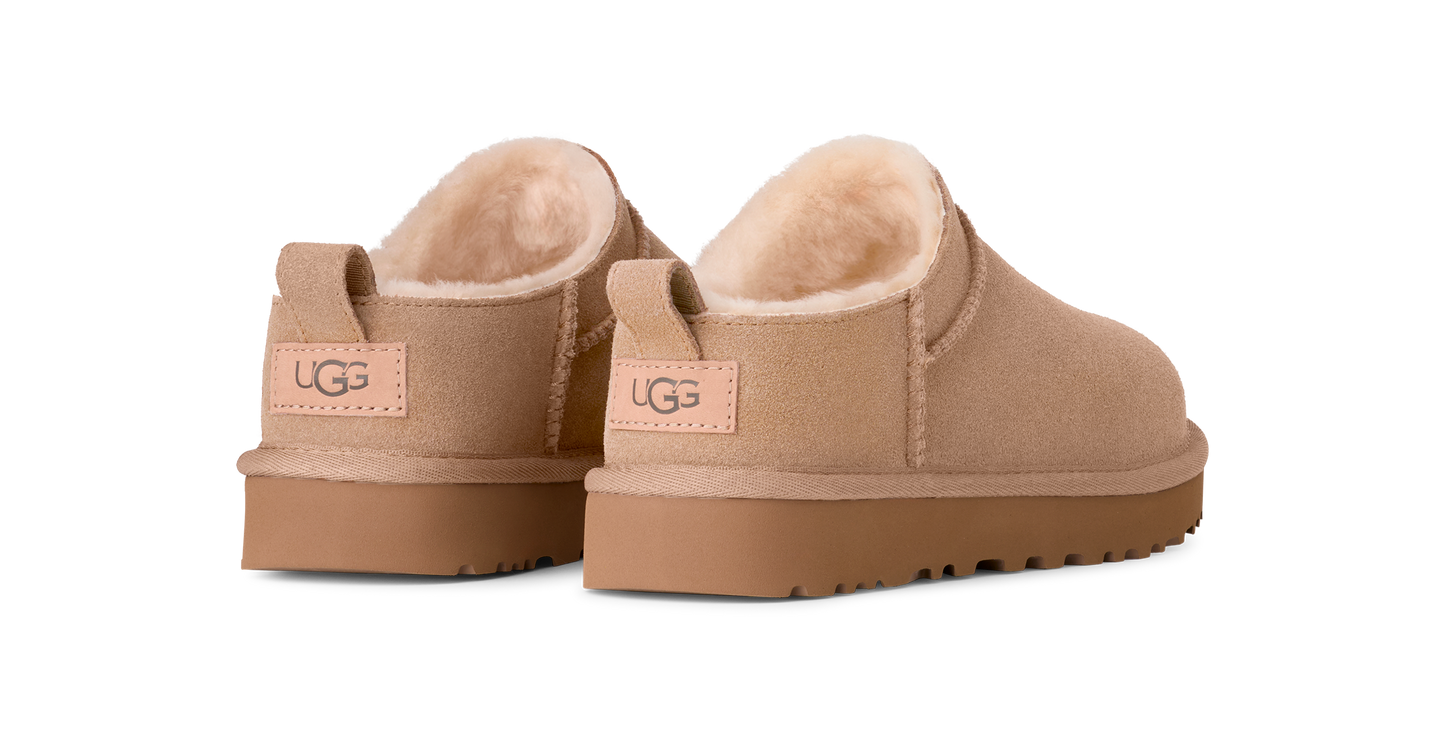Tan UGG brand slipper shoes showing the heel with a tan UGG label on the back.