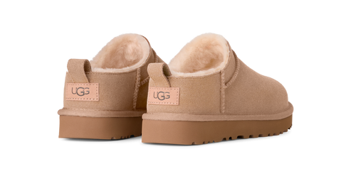 Tan UGG brand slipper shoes showing the heel with a tan UGG label on the back.