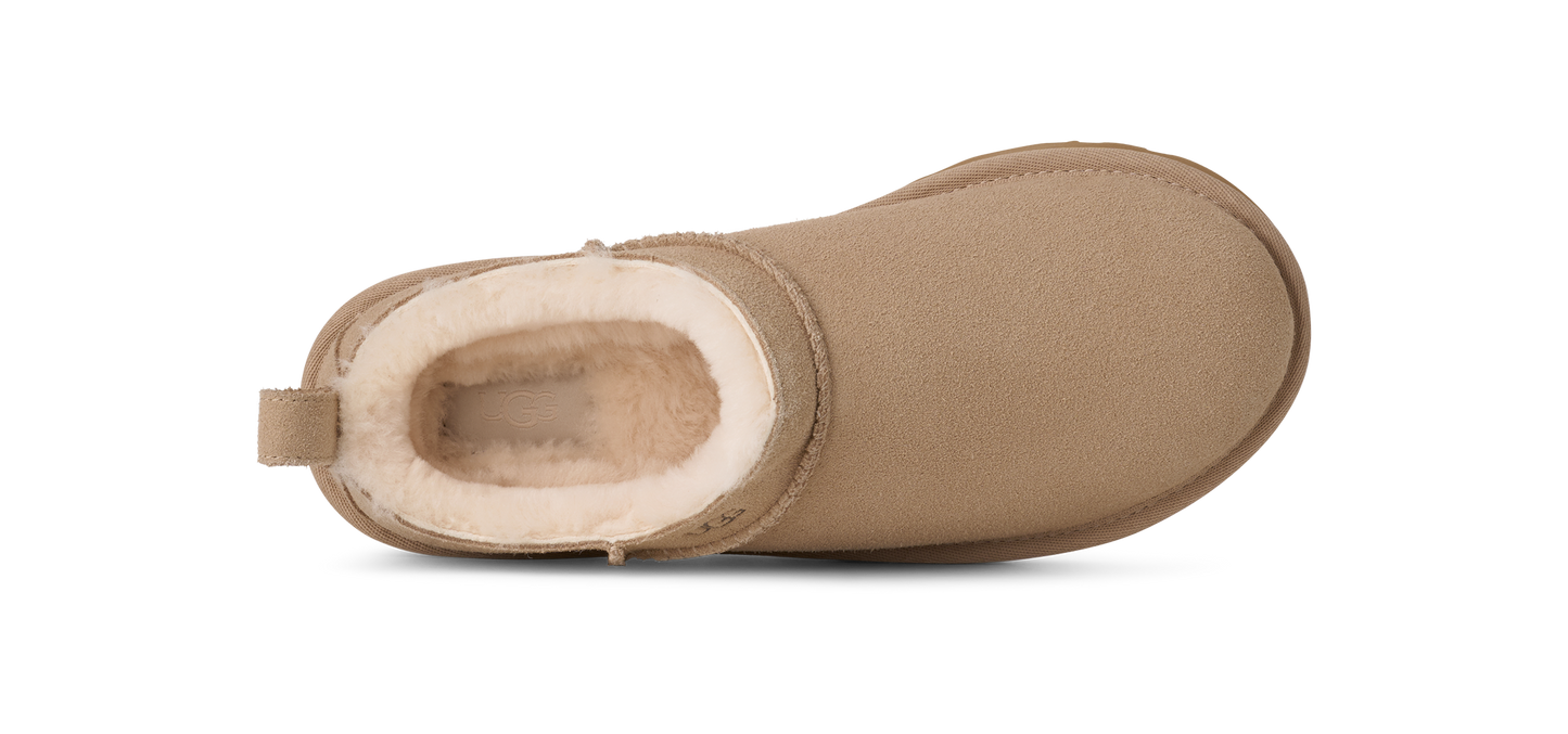 A close-up shot of a beige Ugg boot with white fur.