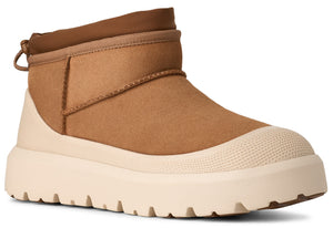 A tan suede ankle boot featuring a thick, off-white textured rubber sole with a molded toe cap and a pull tab at the back collar.