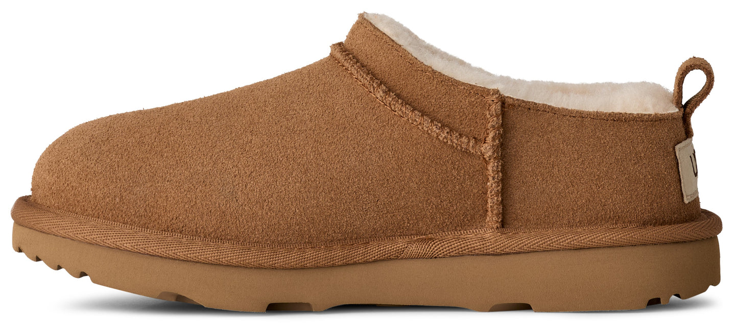 A tan-colored slipper with a round toe and a thick sole, lined with cream-colored fur.