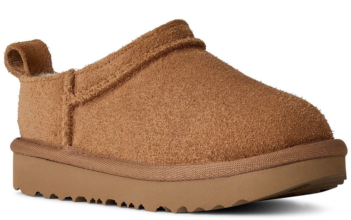 Closed-toe brown slipper with low platform sole and a pull tab on the heel.