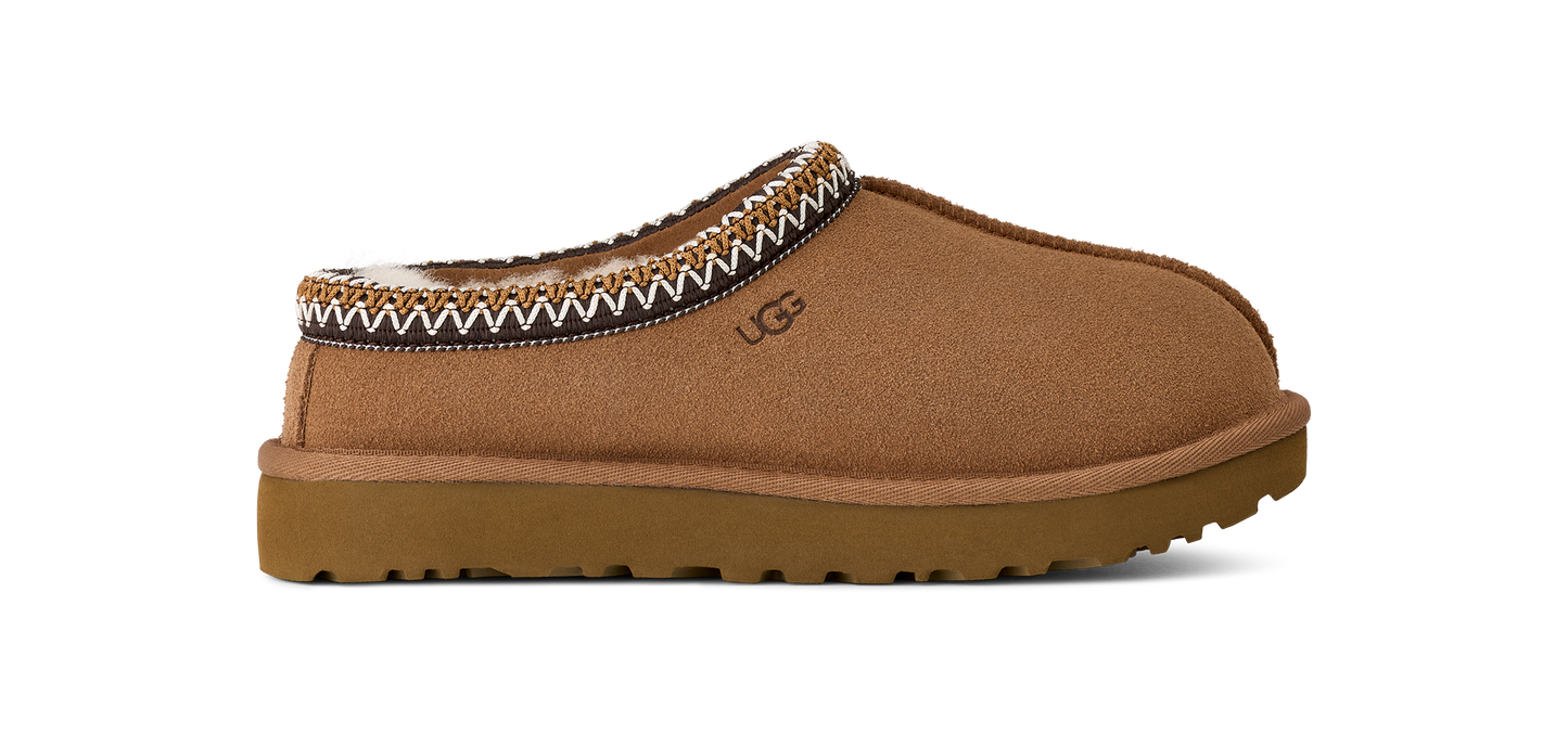 A tan UGG slip-on shoe with decorative trim.