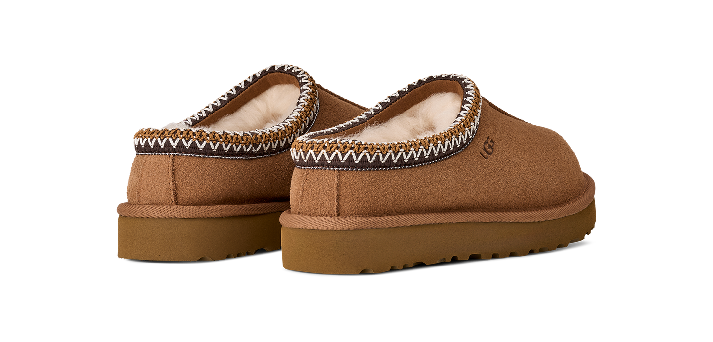 A pair of brown UGG slip-on shoes with white trim and a flat sole.