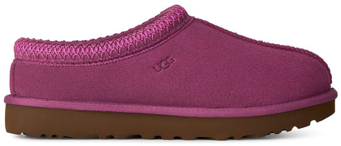 A fuchsia suede slipper with a braided trim around the collar, a flat brown rubber sole, and the UGG logo embossed on the side.